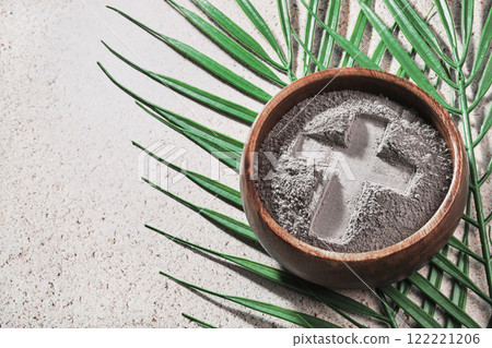 Ash Wednesday. Cross in ashes and palm leaf on stone background 122221206