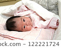 Baby in bed looking into the camera 122221724