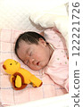 Baby sleeping in bed with a teddy bear 122221726