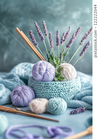 Beautiful yarn arrangement with lavender and knitting tools on a soft blue backdrop Beautiful yarn arrangement with lavender and knitting tools on a soft blue backdrop 122222044