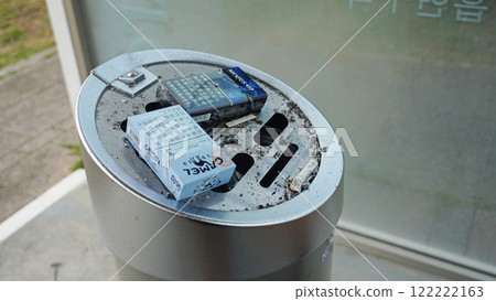 Garbage scattered on an ashtray in a smoking area 122222163
