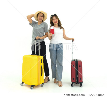 Young asian woman in white t-shirt and middle-aged woman in gray t-shirt stand smiling with luggage, travel passport, airline ticket, sunglasses and straw hat. Summer travel concept. 122223864