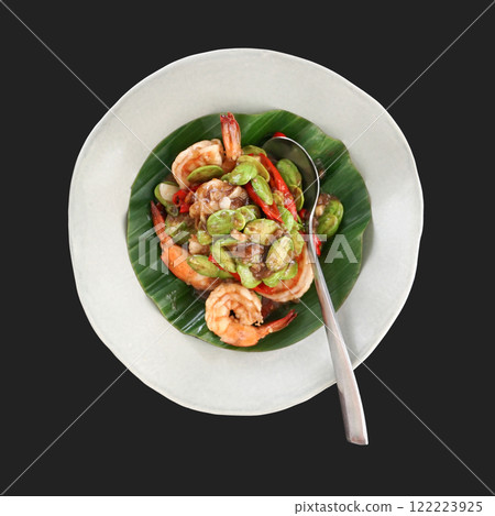 Stir-fried bitter bean with prawn and fresh chilli. Thai style stir-fried vegetable decorated with banana leaves served on white plate. Top view 122223925