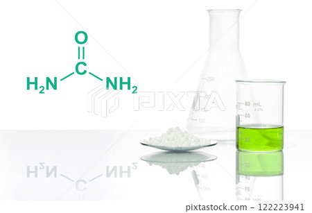 Carbamide in Chemical Watch Glass and Iron (II) sulfate liquid in Beaker place next to Erlenmeyer flask, with the complex laitmotif of a chemical compound structure. Carbamide in Chemical Watch Glass and Iron (II) sulfate liquid in Beaker place next to Erlenmeyer flask, with the complex laitmotif of a chemical compound structure. 122223941