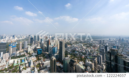 A panoramic view of a bustling city featuring skyscraper and a mix of urban building. The clear sky provide a stunning backdrop to the dynamic landscape below. Bangkok, Thailand. A panoramic view of a bustling city featuring skyscraper and a mix of urban building. The clear sky provide a stunning backdrop to the dynamic landscape below. Bangkok, Thailand. 122224037