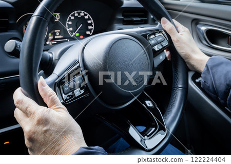 Car steering wheel and hands of elderly driver Car steering wheel and hands of elderly driver 122224404