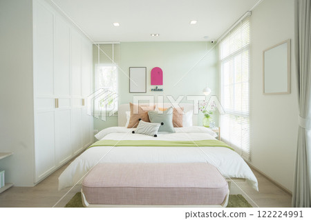 Modern bedroom with green and pink pillows on bed. Stylish bedroom interior design. 122224991