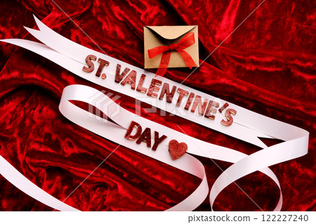 Festive background with the words St. Valentine's Day with red velvet and white ribbon. 122227240