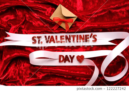 Festive background with the words St. Valentine's Day with red velvet and white ribbon. 122227242