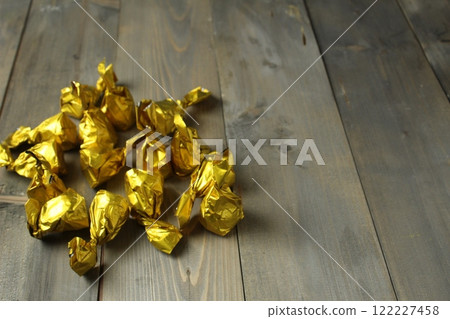 chocolates in golden candy wrappers packaging on a gray background with space for text chocolates in golden candy wrappers packaging on a gray background with space for text 122227458