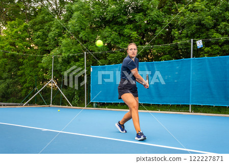 Professional female tennis player playing the tennis on outside court Professional female tennis player playing the tennis on outside court 122227871