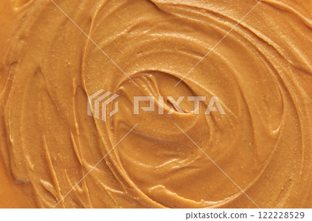 Smooth creamy peanut butter texture with swirls and rich nutty color close up 122228529