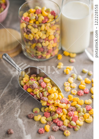 Colorful breakfast cereals in the shape of various fruit on scoop on kitchen table. 122228558