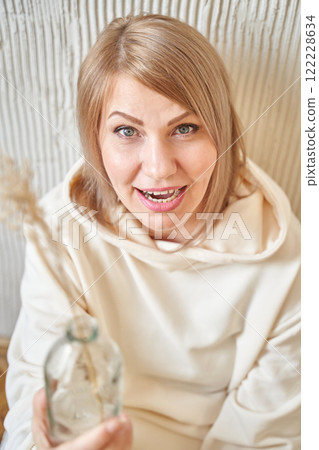 Smiling caucasian female adult with sandy blonde hair in casual outfit holding Smiling caucasian female adult with sandy blonde hair in casual outfit holding 122228634