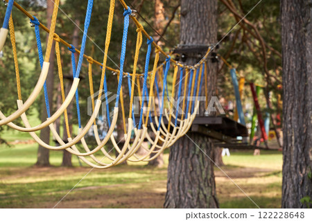 Adventure park rope bridge among trees in forested area for outdoor exploration 122228648