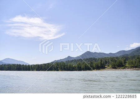 Scenic view of serene lake with lush green forest and mountains under clear blue 122228685