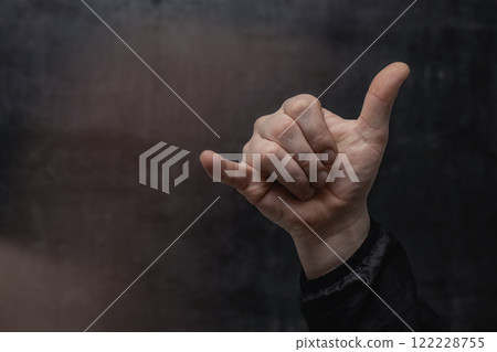 Customer's hand in shirt showing thumb up, close-up on concrete wall background. Service evaluation and a symbol of success. 122228755