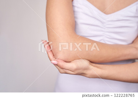 Close up of caucasian female s arm and elbow in white top for skincare or health Close up of caucasian female s arm and elbow in white top for skincare or health 122228765