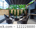 Backyard outdoor bbq zone with pergola, fireplace and hanging chair. Summer party place 122228880