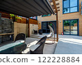 Backyard outdoor bbq zone with pergola, fireplace and hanging chair. Summer party place 122228884
