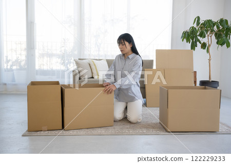 A woman assembling cardboard boxes and moving A woman assembling cardboard boxes and moving 122229233