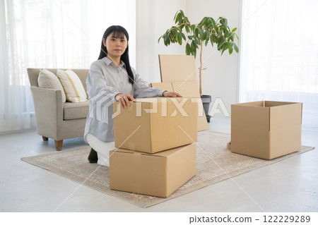 A woman assembling cardboard boxes and moving A woman assembling cardboard boxes and moving 122229289
