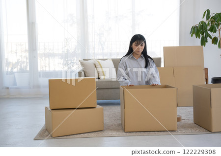 A woman assembling cardboard boxes and moving A woman assembling cardboard boxes and moving 122229308