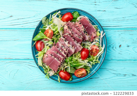 Salad with raw tuna , sesame and cherry tomatoes photography . Top view 122229833