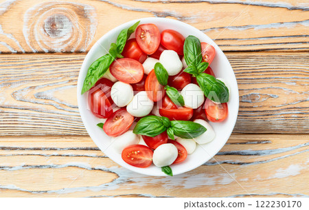 Basil leaves , cherry tomatoes and mozzarella cheese . In bowl food photography 122230170