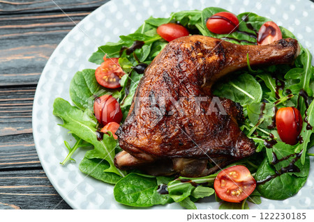 Grilled chicken legs with tomatoes and salad . Top view 122230185