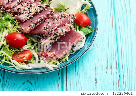 Salad with raw tuna , sesame and cherry tomatoes photography . Top view 122230401