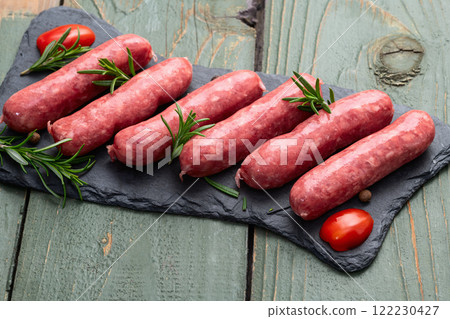 Raw beef sausages with rosemary and tomatoes photography . Top view 122230427