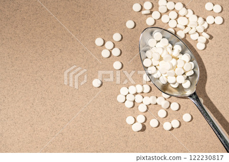 Sugar substitute, sweetener pills in a spoon, top view. Food supplement. Diabetic, over weight, health concept. Copy space Sugar substitute, sweetener pills in a spoon, top view. Food supplement. Diabetic, over weight, health concept. Copy space 122230817