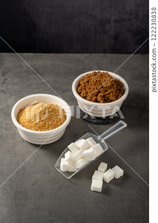 Different type of sugar, light brown, dark brown and white sugar cubes in bowls.  122230838