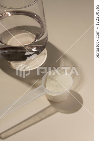 Protein powder, measuring scoop and a glass of water. Nutrition and food supplement Protein powder, measuring scoop and a glass of water. Nutrition and food supplement 122230865