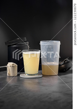 Protein drink or shake in a glass. Food supplements. Dark background. Bodybuilding, fitness, gym. 122230870