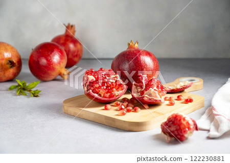 Fresh pomegranates, ripe red pomegranate slices on cutting board. 122230881