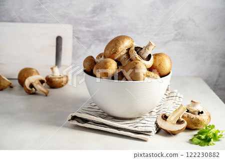 Raw champignon in a bowl on bright background, button mushrooms. Vegan protein.  122230882