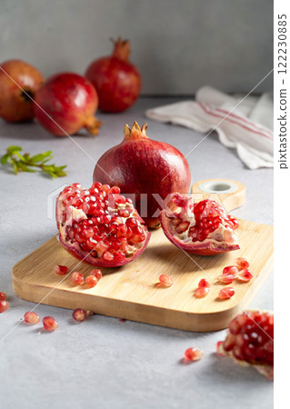 Fresh pomegranates, ripe red pomegranate slices on cutting board. Fresh pomegranates, ripe red pomegranate slices on cutting board. 122230885