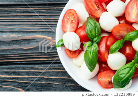 Basil leaves , cherry tomatoes and mozzarella cheese . In bowl food photography 122230999