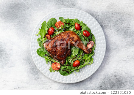 Grilled chicken legs with tomatoes and salad . Top view Grilled chicken legs with tomatoes and salad . Top view 122231020