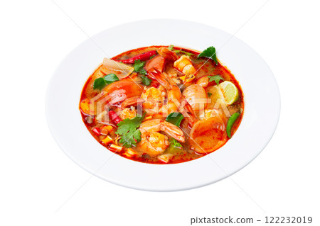 Closeup plate of traditional thai soup - tom yum kung with shrimps and tomatoes isolated at white background. 122232019