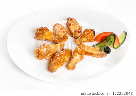 Plate of fried golden chicken wings and legs isolated at white background. 122232048