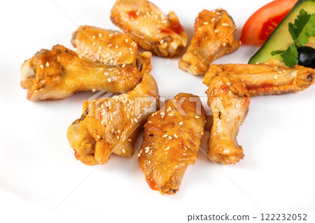 Plate of fried golden chicken wings and legs isolated at white background. 122232052