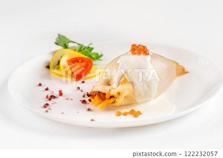 Steamed calamari filled with vegetables decorated with red caviar isolated at white background. 122232057