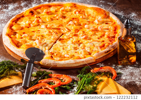 Tasty italian pizza with fresh golden cheese, shrimps and olive oil at wooden background. 122232112