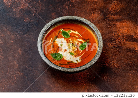 Plate of tomato gaspacho soup served with nuts at concrete textured table background. 122232126