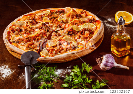 Italian pizza with lemon, cheese and seafood at rustic wooden desk background. Closeup image Italian pizza with lemon, cheese and seafood at rustic wooden desk background. Closeup image 122232167