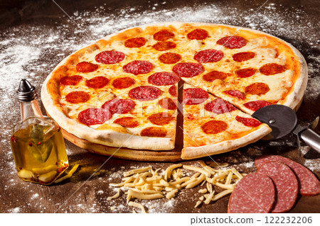 Closeup image of tasty italian pepperoni pizza with salami at wooden table background. 122232206