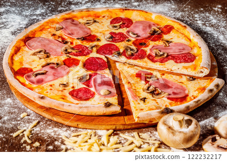 Italian pizza with pepper, cheese, mushrooms and salami at rustic wooden desk background. Closeup image 122232217